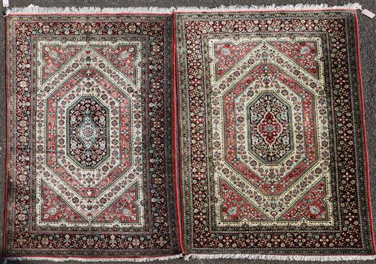 A mathched pair of Qum silk rugs, 5ft 4in by 3ft 4in.